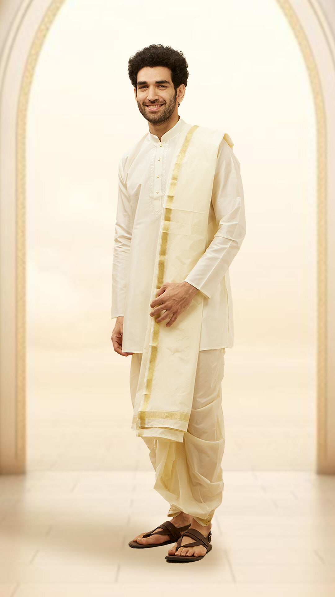 A groom in white kurta dhoti for wedding reception